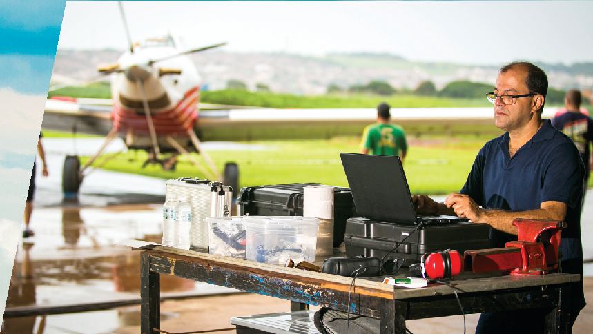 Técnico realizando diagnóstico eletrônico em pista de pouso